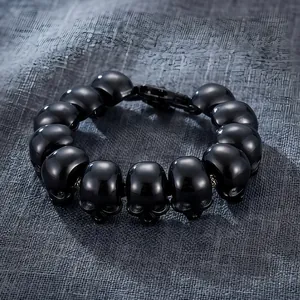 Macro detail of a high-gloss black titanium steel skull bracelet for men in gothic style