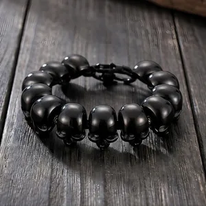Close-up detail of glossy black titanium steel skull beads on a gothic men's bracelet