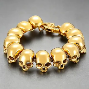 Detailed macro view of a gold-plated titanium steel skull link bracelet for men.