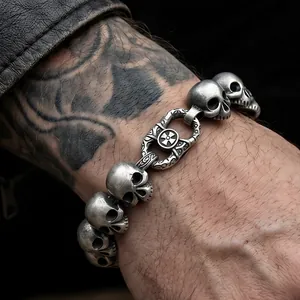 Close-up of gothic vintage stainless steel skull bracelet for men on a tattooed wrist