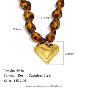 Detail of amber resin bead necklace with a polished 18K gold-plated heart pendant.