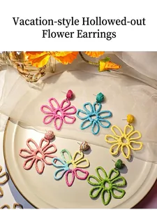 Detail of colorful hand-woven raffia flower earrings in various vibrant summer hues.