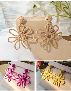 Detailed view of handmade raffia woven hollow flower earrings in multiple summer colors