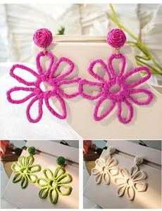 Detail view of handmade woven raffia flower earrings for summer vacation