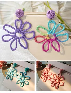 Close-up of colorful handmade woven raffia flower earrings in various vacation styles