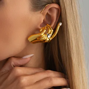 Vue détaillée d'un tour d'oreille doré en forme de main avec des strass brillants.