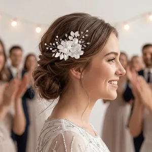 Barrette à fleurs blanches en acrylique et perles dans un chignon de mariée élégant.