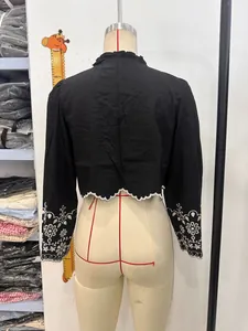 Back view of black shirt with white floral embroidery and scalloped lace hem