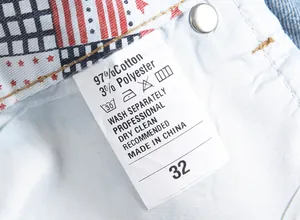 Detail shot of men's denim shorts care label with 97% cotton material and size 32