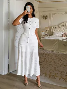 Vue détaillée d'une robe longue blanche élégante à manches courtes boutonnée devant.