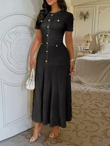 Robe longue noire chic à manches courtes avec boutons dorés et maille texturée.