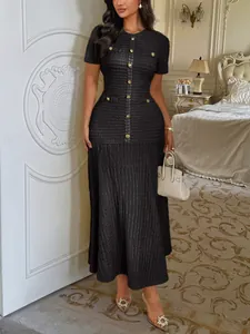 Robe longue élégante en tweed noir avec boutons dorés dans un décor intérieur luxe