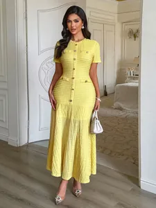 Vue complète d'une élégante robe longue jaune texturée à manches courtes avec boutons sur le devant
