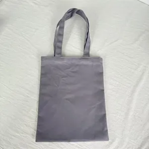 Detailed view of the solid purple thick canvas tote bag on a white textured background