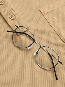Macro view showing the breathable pique fabric texture and buttons of a men's tan polo shirt