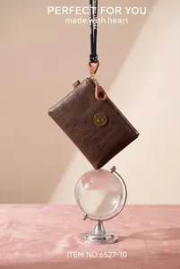 Macro view of a brown textured PU leather coin purse with lanyard and zipper detail