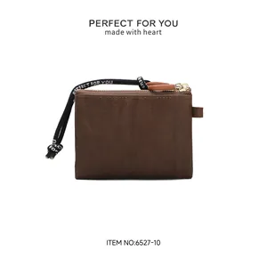 Back view of minimalist dark brown PU leather coin purse with heart strap for women