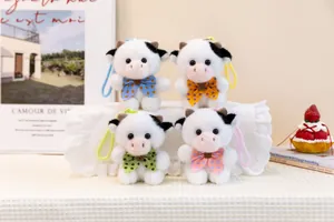 Detail shot of four cute plush cow keychains featuring colorful polka-dot bowties