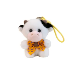 Adorable fluffy dairy cow plush toy pendant featuring a yellow polka dot bow tie keychain