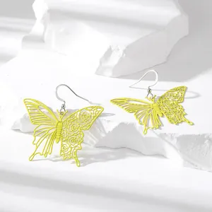 Vibrant yellow butterfly hollow earrings with floral engraving details