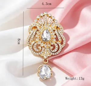 Vue détaillée d'une broche couronne goutte d'eau avec strass brillants et dorure