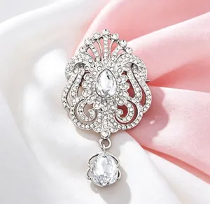 Gros plan d'une broche couronne argentée vintage avec cristaux en forme de larme