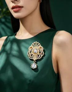 Élégante broche vintage en strass doré en forme de goutte sur une robe en soie verte