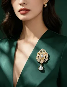 Broche couronne élégante avec strass goutte d'eau sur un blazer vert foncé chic
