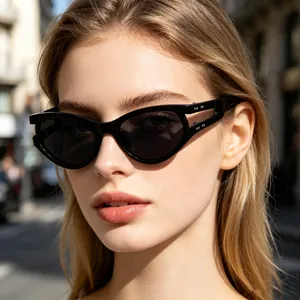 Detail view of stylish black oval cat-eye sunglasses worn by a female model outdoors