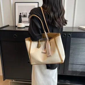 Elegant cream and brown large capacity tote bag shown being worn by a model
