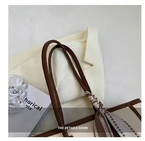 Detail of comfortable brown shoulder straps on a minimalist cream fashion tote bag