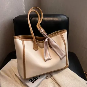 Elegant cream white tote bag with brown trim and decorative silk scarf detail
