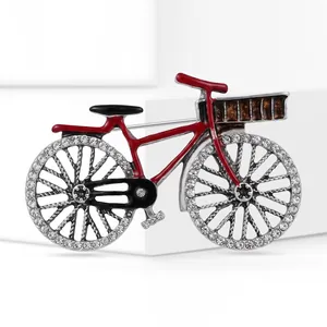 Close-up of a vintage red bicycle brooch featuring sparkling rhinestone encrusted wheels