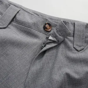Close-up detail of elegant grey straight skirt featuring button and zipper closure