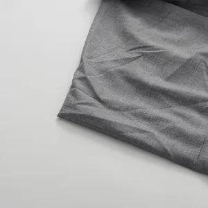 Close-up detail of the premium textured grey fabric and stitching on a pleated skirt.