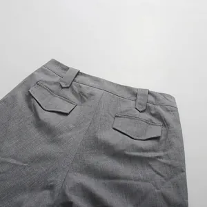 Detailed view of the back waist and flap pockets of a gray straight skirt