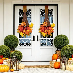 Decorative autumn gnome wreaths with colorful maple leaves hanging on white front doors
