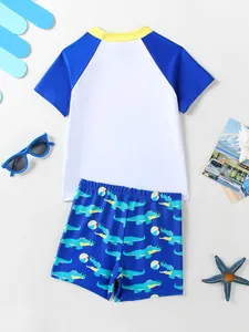 Detail view of boys two-piece swimwear set featuring cartoon crocodile print shorts
