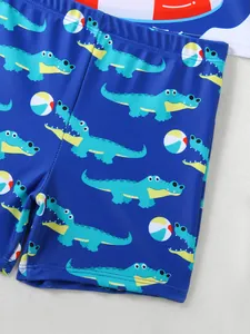 Close-up detail of boys' quick-dry swim trunks with cute cartoon crocodile pattern