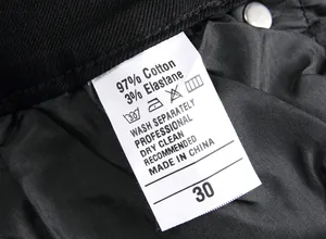 Close-up detail of care label showing material composition for men's black stretch jeans