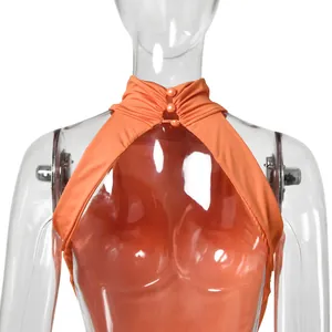 Detail of an elegant orange halter evening gown with stylish pearl button neckline.