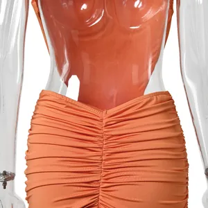 Macro detail of the orange ruched fabric on a sexy backless mermaid evening gown