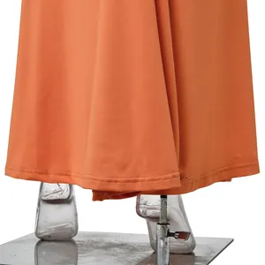 Detailed view of the elegant orange evening gown's hemline and smooth fabric texture