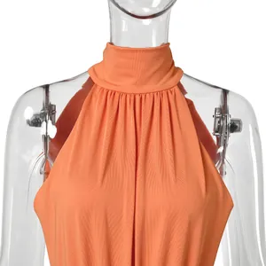 Close-up detail of an elegant orange halter neck evening gown with fine pleated texture.