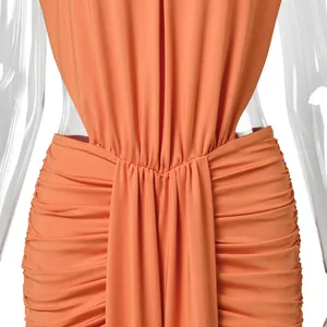 Detail view of orange elegant evening gown showing intricate ruched fabric and slim fit design.