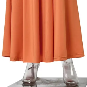 Close-up of the elegant orange evening maxi dress hemline and fabric texture.
