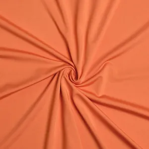 Close-up view of vibrant orange pleated fabric texture for an elegant mermaid evening gown
