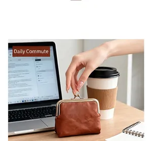 Vintage brown kiss-lock coin purse displayed on a desk next to a coffee cup and laptop.