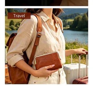 Vintage brown leather kiss-lock coin purse held by a woman during outdoor travel