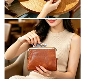 Detailed macro view of a vintage brown leather clasp purse for women being used as wallet